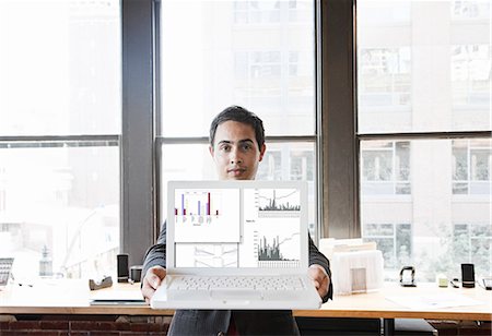 simsearch:6118-09139986,k - Hispanic man with his laptop at his office workstation. Foto de stock - Sin royalties Premium, Código: 6118-09140010