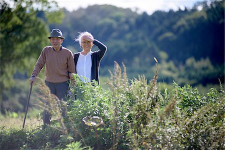 simsearch:700-05973994,k - Husband and wife, elderly man wearing hat and using walking stick and elderly woman walking along path. Photographie de stock - Premium Libres de Droits, Code: 6118-09147933