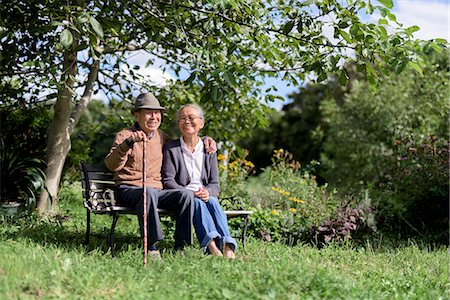 simsearch:700-05973994,k - Husband and wife, elderly man wearing hat and woman sitting side by side on a bench in a garden. Photographie de stock - Premium Libres de Droits, Code: 6118-09147930