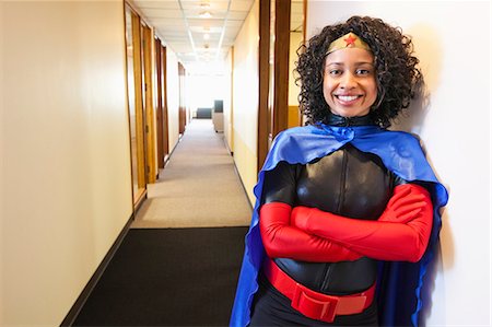 female superhero - A black businesswoman office super hero standing in a hallway of her office. Stock Photo - Premium Royalty-Free, Code: 6118-09148015