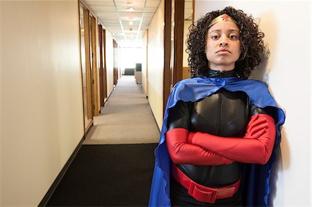 simsearch:6118-09147986,k - A black businesswoman office super hero standing in a hallway of her office. Fotografie stock - Premium Royalty-Free, Codice: 6118-09148016
