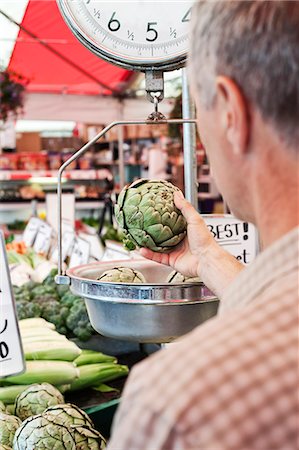 simsearch:6118-09148131,k - Over the shoulder view of man weighing artichoke at a fruit and vegetable market. Stock Photo - Premium Royalty-Free, Code: 6118-09148113