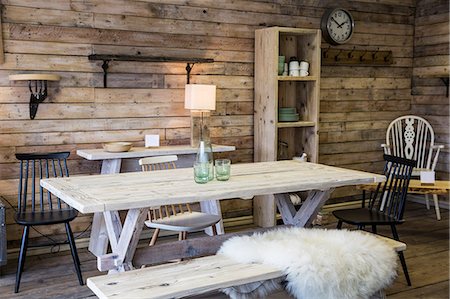 rustic workshop - Display of furniture made from recycled wood, including dining table and bench, bookshelf and chair, wooden floor and wall. Stock Photo - Premium Royalty-Free, Code: 6118-09148249