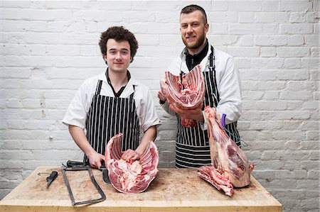 simsearch:6118-08729219,k - Two butchers side by side holding meat joints, part of a large butchered carcass. Foto de stock - Sin royalties Premium, Código: 6118-09165867