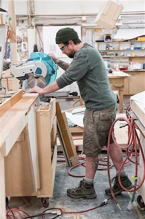 simsearch:6118-08729048,k - Caucasian male carpenter using a radial saw to cut a piece of wood in a large woodworking factory. Photographie de stock - Premium Libres de Droits, Code: 6118-09166041