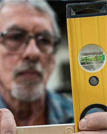 simsearch:649-07905311,k - A senior man with glasses and beard in a woodworkers shop, using a spirit level checking his work. Stock Photo - Premium Royalty-Free, Code: 6118-09166030