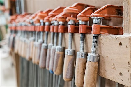 fait à la main - Close up of small bar clamps being used in a woodworking factory. Photographie de stock - Premium Libres de Droits, Code: 6118-09166038