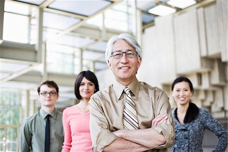 simsearch:6118-09139994,k - A portrait of a mixed race team of business people standing in the lobby area of a convention centre with an Asian businessman in the lead. Foto de stock - Sin royalties Premium, Código: 6118-09166199