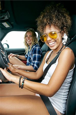 simsearch:6118-09165914,k - Portrait of two women with long blond and brown curly hair sitting in car, wearing sunglasses, smiling. Foto de stock - Royalty Free Premium, Número: 6118-09166291