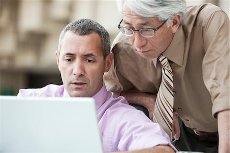 simsearch:614-07487219,k - An Asian businessman and Caucasian businessman working on lap top computer in the lobby of a convention centre. Fotografie stock - Premium Royalty-Free, Codice: 6118-09166214