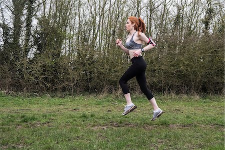 simsearch:6118-09165967,k - Young woman with long red hair wearing sports kit, exercising outdoors. Foto de stock - Sin royalties Premium, Código: 6118-09173439