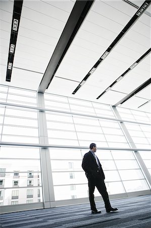 simsearch:6118-09173924,k - Businessman standing against a window in a conference centre lobby. Stockbilder - Premium RF Lizenzfrei, Bildnummer: 6118-09173542