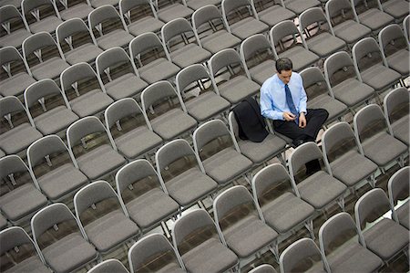 simsearch:6118-09173924,k - View from above looking down on a businessman sitting alone in a room full of chairs prior to meeting in a conference centre. Stockbilder - Premium RF Lizenzfrei, Bildnummer: 6118-09173561