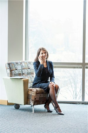 simsearch:6118-09173926,k - A young Caucasian woman talking on her phone in an office lobby. Stock Photo - Premium Royalty-Free, Code: 6118-09173578