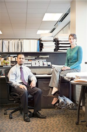 Portrait of a young Black businessman and Caucasian businesswoman in an office cubicle. Stock Photo - Premium Royalty-Free, Code: 6118-09173594