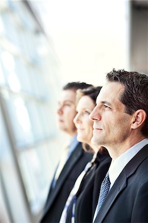 simsearch:6118-09173926,k - Group of three business people looking out the window of a conference centre lobby. Stock Photo - Premium Royalty-Free, Code: 6118-09173525