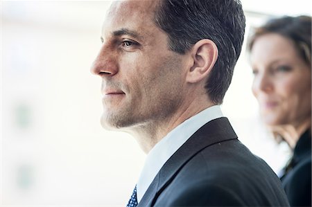 simsearch:6118-09173926,k - Close-up of a Caucasian businessman looking out the widow of a conference centre lobby. Stock Photo - Premium Royalty-Free, Code: 6118-09173530