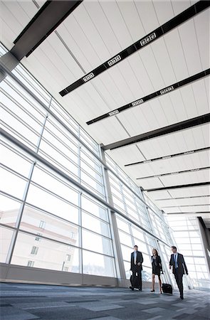 simsearch:6118-09173926,k - Three business people walking next to a large window in a conference centre lobby. Stock Photo - Premium Royalty-Free, Code: 6118-09173535