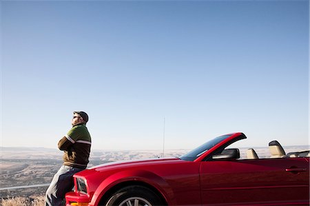 ford mustang - A Caucasian man resting on the hood of his convertible sports car at a rest stop. Fotografie stock - Premium Royalty-Free, Codice: 6118-09173680