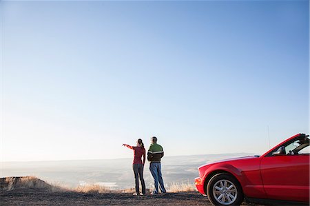 A young Caucasian couple admires the view at a rest stop in Eastern Washington, USA while on a road trip with their convertible sports car. Stock Photo - Premium Royalty-Free, Code: 6118-09173614