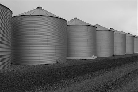 simsearch:6118-09173815,k - Rows of grain silos, stormy skies in distance, Saskatchewan, Canada. Foto de stock - Sin royalties Premium, Código: 6118-09173769