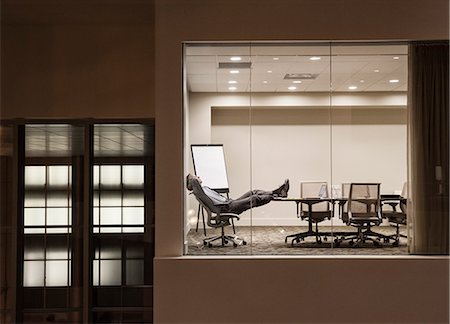 sleeping on boardroom table - A view looking into a conference room at night  with a single businessman at a conference table. Stock Photo - Premium Royalty-Free, Code: 6118-09173885