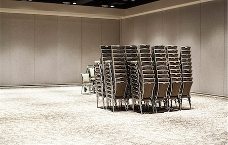 Stacked chairs in an empty convention centre meeting room. Stock Photo - Premium Royalty-Free, Code: 6118-09173902