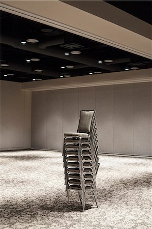Stacked chairs in an empty convention centre meeting room. Stock Photo - Premium Royalty-Free, Code: 6118-09173904