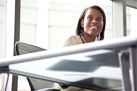 simsearch:6118-09173926,k - A black businesswoman listening during a meeting in a convention centre meeting room. Stock Photo - Premium Royalty-Free, Code: 6118-09174093