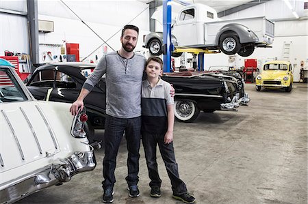 restoring car in garage - A portrait of a Caucasian male and his young son in their classic car repair shop. Stock Photo - Premium Royalty-Free, Code: 6118-09174030