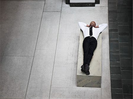 simsearch:6118-09173924,k - A view looking down on a businessman taking a break laying down on a bench. Stockbilder - Premium RF Lizenzfrei, Bildnummer: 6118-09174105