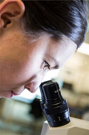 simsearch:6118-09173989,k - A Caucasian female technician using a microscope to examine a part in a technical research and development site. Foto de stock - Sin royalties Premium, Código: 6118-09174135