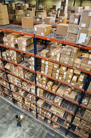 simsearch:6118-09174185,k - A view from above looking down on a warehouse worker checking inventory of boxes on racks in a distribution warehouse. Stockbilder - Premium RF Lizenzfrei, Bildnummer: 6118-09174221