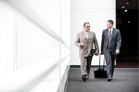 simsearch:6118-09129966,k - An Hispanic businessman and a Caucasian businessman walking and talking together in a convention centre lobby, Stock Photo - Premium Royalty-Free, Code: 6118-09174378