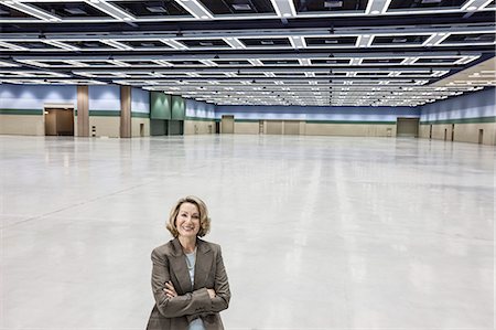 simsearch:6118-09173926,k - A portrait of a Caucasian businesswoman in a convention centre arena area. Stock Photo - Premium Royalty-Free, Code: 6118-09174401