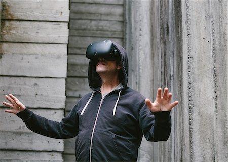 escapism - A middle aged man wearing a virtual reality headset. Stock Photo - Premium Royalty-Free, Code: 6118-09174417