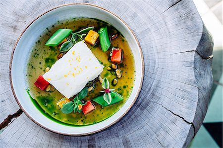 simsearch:6118-07808970,k - Pouring broth on halibut with lemon, peas, melon, beets and herbs Stock Photo - Premium Royalty-Free, Code: 6118-09174502