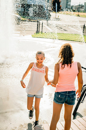 Smiling girls playing in public fountain in summer Stock Photo - Premium Royalty-Free, Code: 6118-09183243