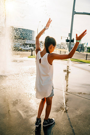 Girl playing in public fountain in summer Stock Photo - Premium Royalty-Free, Code: 6118-09183245