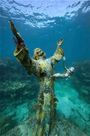 fond marin - A young woman snorkels near the Christ of the Abyss Statue, Key Largo, Florida Keys.  The bronze statue was submerged in the waters of Key Largo, Florida in 1965. Photographie de stock - Premium Libres de Droits, Code: 6118-09112149