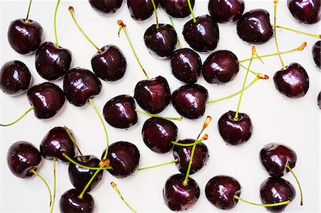 High angle close up of ripe red cherries spread out on a worktop. Fotografie stock - Premium Royalty-Free, Codice: 6118-09112117