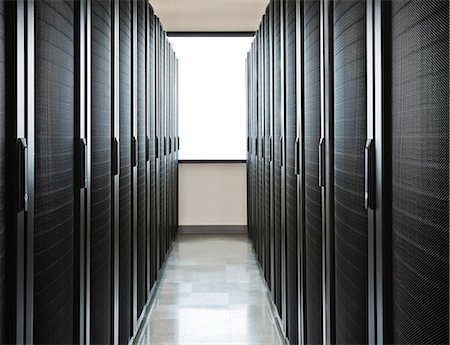 simsearch:6118-09129487,k - Storage racks aligned in a computer server room with a large window in the background. Photographie de stock - Premium Libres de Droits, Code: 6118-09129375