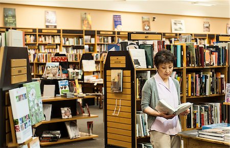 simsearch:6118-07354058,k - Asian American female browsing through books in a bookstore. Stock Photo - Premium Royalty-Free, Code: 6118-09129464