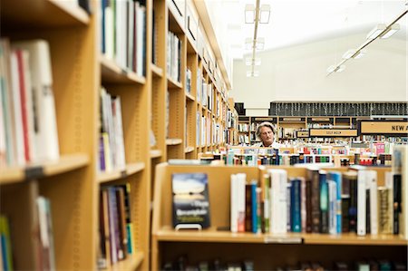 simsearch:6118-07354058,k - Caucasian male browsing through books in a large bookstore. Stock Photo - Premium Royalty-Free, Code: 6118-09129465