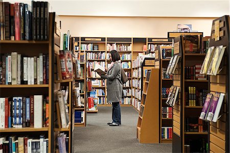 Caucasian female browsing through books in a bookstore. Photographie de stock - Premium Libres de Droits, Code: 6118-09129469