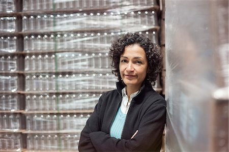 simsearch:6118-09129432,k - Portrait of an African American female manager in a storage warehouse for pallets of flavoured bottled water. Fotografie stock - Premium Royalty-Free, Codice: 6118-09129418