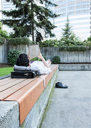 Businessman in a downtown city park taking a break and checking his computer notebook Stock Photo - Premium Royalty-Free, Code: 6118-09129530