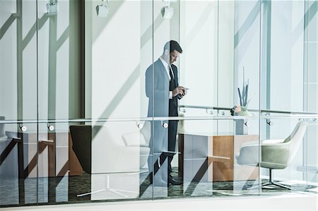 simsearch:6118-07351305,k - Businessman standing behind a conference room window in a large business centre. Stock Photo - Premium Royalty-Free, Code: 6118-09129644