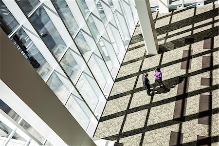 simsearch:6118-09129521,k - Black businessman and woman meeting next to a large bank of windows in the lobby of a large business centre. Stock Photo - Premium Royalty-Free, Code: 6118-09129648