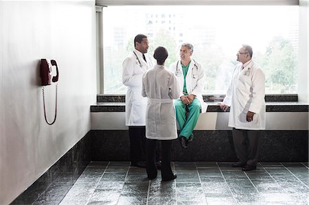 restregar - Mixed race doctors conferring in a hospital hallway. Foto de stock - Sin royalties Premium, Código: 6118-09129680